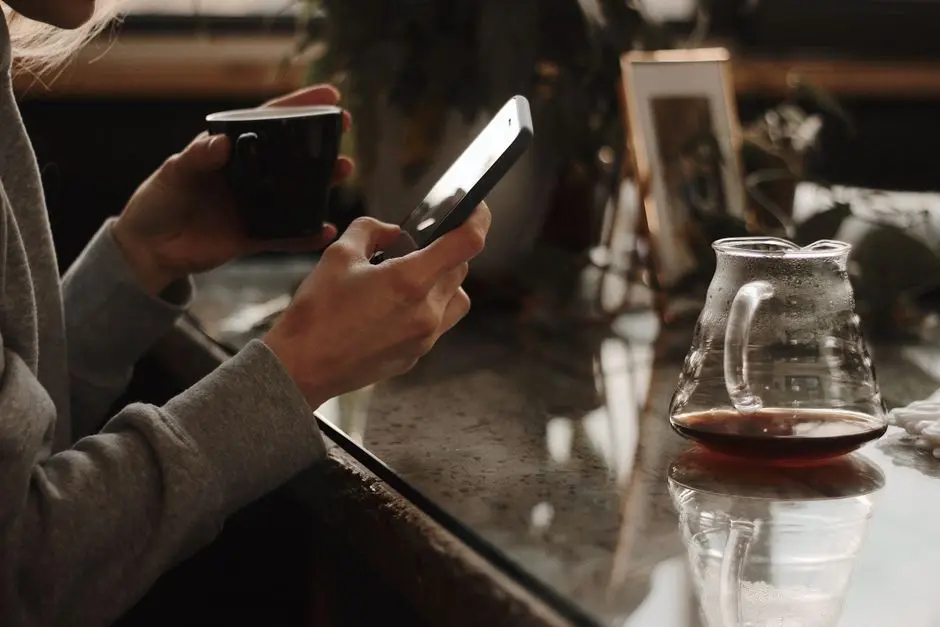 Suasana pagi dengan ponsel dan secangkir kopi di meja